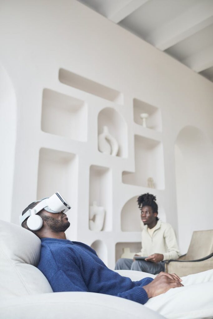 A Man in Blue Sweater Relaxing on a Chair while Wearing Virtual Reality Headset